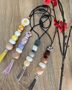 a bunch of different colored beads and tassels sitting on a table next to a flower