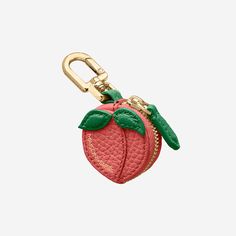 a red apple shaped keychain with a green leaf on the front and bottom