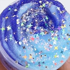 a hand holding a container filled with blue and white stars