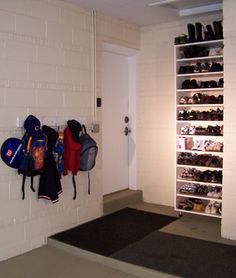 there are many pairs of shoes hanging on the wall next to the door in this room