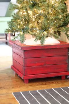 a small christmas tree in a wooden box on the floor next to a rug and chair