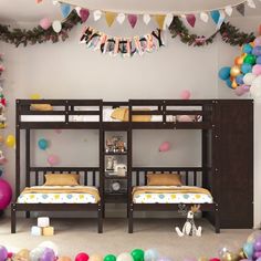 two bunk beds in a room with balloons and streamers on the wall behind them