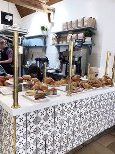 a table with breads and pastries on it in a kitchen area at a restaurant