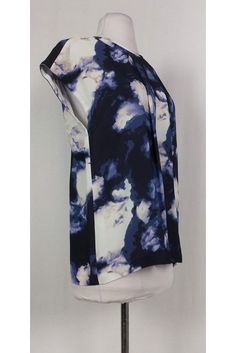 This casual top is made with an eye-catching abstract print. Pleated front and keyhole back add a feminine touch. Great for a day of errands, this top can be paired with skinny jeans and flats. Size 8 100% viscose Rounded neckline Short sleeve Slips on Pleated front Bust 38" Shoulder to hem 25.5" Trendy Blue Top With Abstract Print, Trendy Blue Abstract Print Top, Chic Blue Top With Abstract Print, Casual Sleeveless Top With Abstract Print, Casual Abstract Print Tops For Work, Casual Tops With Abstract Print For Work, Trendy Abstract Print Tops For Work, Modern Summer Tops With Abstract Print, Chic Abstract Print Top For Workwear