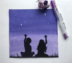 two children are silhouetted against the night sky with their hands up in the air