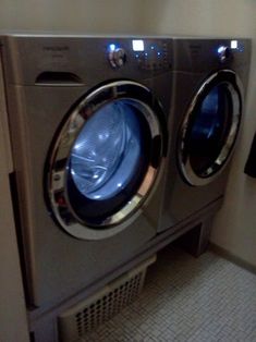 a washer and dryer in a room with tile flooring on the walls