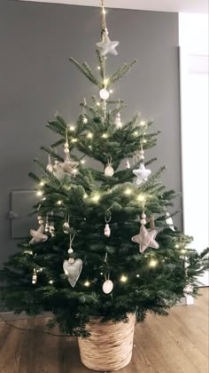 a small christmas tree in a basket on the floor