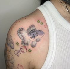 a woman with a tattoo on her shoulder has a fish and butterflies design on it