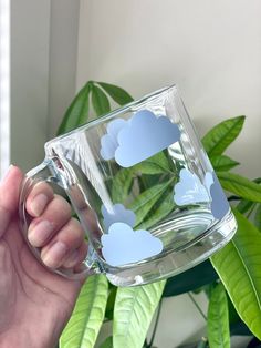 Serve your next drink from this cute cloud cup! This adorable 13 oz (384 ml) glass mug is perfect any beverage - sodas, iced coffee, or anything really! It's the perfect gift for birthdays, house warming or for any other any occasion! Glass Mug Care * Hand wash ONLY * Do not soak  * Dry with soft towel * Do not put in microwave NOTE: Since the designs on these cups are made with permanent vinyl, which is essentially a sticker. These designs are not meant to last forever, the longevity is based o Rain Cloud Mug, Glass Drinking Cups, Clear Mugs With Vinyl, Cute Coffee Mugs Designs, Cup Decoration Ideas, Glass Mugs With Vinyl, Mug Ideas Design, Cricut Glass Cups, Cute Mug Designs