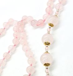 Rose Quartz pink gemstone silk knotted beaded 32 inch necklace. Good used condition with little to no signs of normal wear. Necklace features 8 mm rose quartz beads with two sections of gold toned flower capped 12 mm beads. Gemstones tested with Presidium II gemstone tester. Necklace measures 32 inches long. Quartz Pink, Rose Quartz Beads, Quartz Beads, Pink Gemstones, Rose Quartz, Gold Tones, Silk, Gemstones, Signs