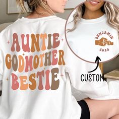 Auntie Godmother Bestie Sweatshirt, Auntie Shirt, Godmama Sweater, Funny Godparent Sweater, Aunt Gift, Godmother Gifts, Aunt God Mother Gift ---------------------- 🛍️ How to Order Your Perfect T-Shirt 🌟 Welcome to our shop! We're thrilled you're here to customize your ideal T-shirt. To make your shopping experience seamless, follow these simple steps: 1️⃣ Explore All the Details: Take a close look at all the photos to ensure you know exactly what you're getting. 2️⃣ Size Matters: Use the conve Casual White Tops For Family Gatherings, White Long Sleeve Tops For Family Occasions, White Long Sleeve Tops, Long Sleeve T-shirt For Mother's Day Family Event, Aunt Hoodies, Godmother Sweatshirt, Auntie Sweatshirt With Names, Auntie Era Sweatshirt, Family Long Sleeve T-shirt For Mother's Day