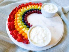 a white plate topped with fruit and dips