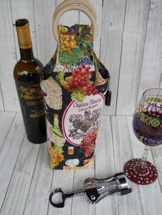 a wine bottle, corkscrew and glass on a white wooden surface with a corkscrew in the foreground