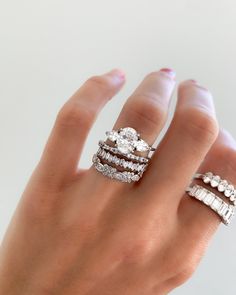 a woman's hand with three rings on top of her finger and one ring in the middle