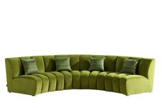 a green sectional couch with pillows on it's back and side facing the camera