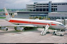 an airplane is parked on the tarmac in front of a building with several windows