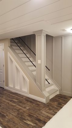 an empty room with stairs leading up to the second floor and another door on the other side