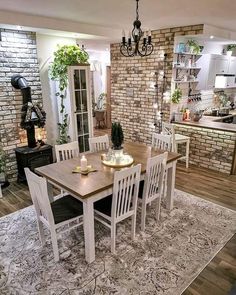 a dining room table and chairs in front of a brick wall with potted plants on it