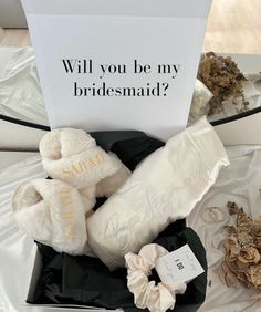 the bridesmaid gift box is filled with white teddy bears and other wedding accessories