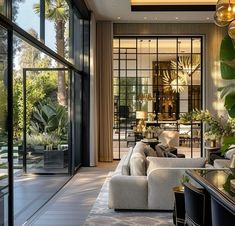 a living room filled with lots of furniture and plants on the side of the wall