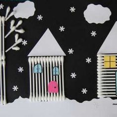 a paper cut out of some houses and trees in the snow