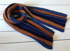 an orange and blue striped scarf laying on top of a white table