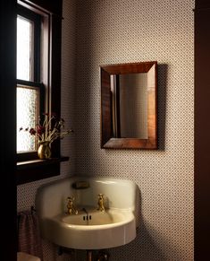 a bathroom sink sitting under a mirror next to a window