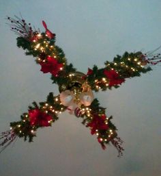 a cross decorated with christmas decorations and lights