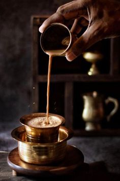 a person pouring coffee into a cup