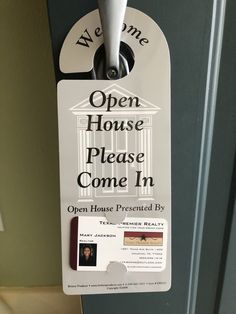 an open house sign hanging from the side of a door