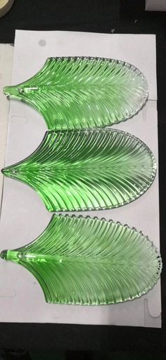 three green glass plates sitting on top of a table