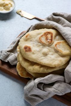 three pita breads on a wooden cutting board