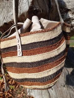 These individually woven colourful bags were woven by women in certain regions of Kenya https://en.wikipedia.org/wiki/Kiondo. The weaving skills were handed down from mothers and grandmothers. This bag has interwoven colours of shades of brown and beige. This bag is unique and is the only one of it's kind in the world. Multicolor Woven Leather Bags, Brown Woven Leather Basket Bag, Woven Leather Basket Bag, Brown Woven Leather Basket Bucket Bag, Woven Leather Basket Shoulder Bag, Beige Woven Leather Basket Shoulder Bag, Brown Woven Leather Bucket Bag, Traditional Woven Leather Shoulder Bag For Daily Use, Bohemian Natural Woven Leather Bags