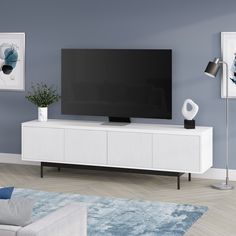 a flat screen tv sitting on top of a white entertainment center in a living room