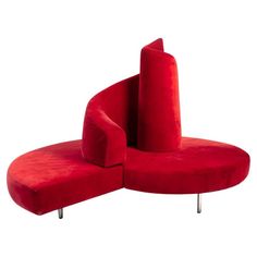 a red couch with two curved seats on it