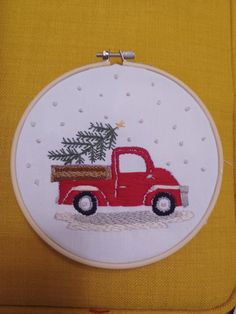 a red truck with a christmas tree in the back is shown on a yellow piece of fabric