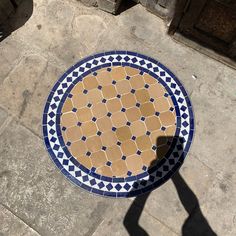 a blue and white plate sitting on top of a cement floor next to a door