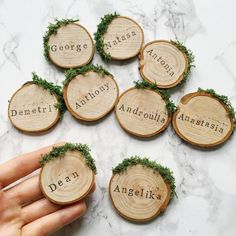 hand holding six wooden slices with names on them