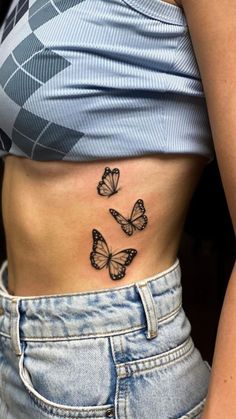 a woman's stomach with three butterflies on her left side, and the lower part of