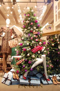 a christmas tree in a store window with shoes on display