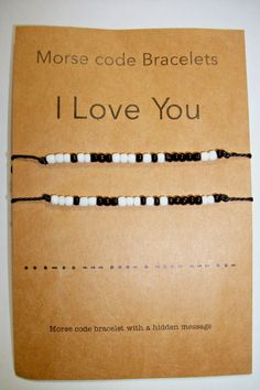 two black and white beaded bracelets on brown paper with the words morse code bracelets i love you