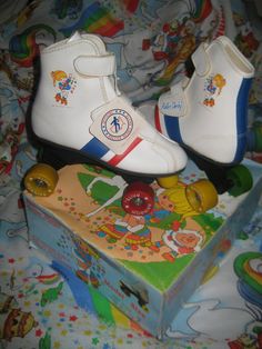 a pair of white shoes sitting on top of a box next to a toy mouse