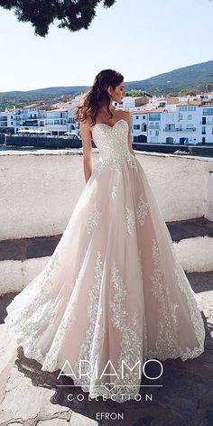 a woman in a wedding dress is standing on the ledge