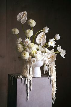 a white vase filled with flowers on top of a table