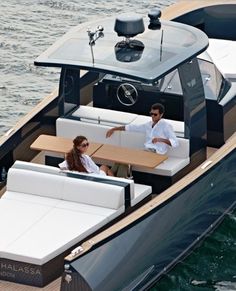 two people sitting on the back of a boat