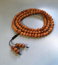 Adjustable Spiritual Mala For Puja, Holistic Hand Knotted Jewelry For Rituals, Bohemian Adjustable Mala For Puja, Handmade Spiritual Mala With Oval Beads, Brown Wooden Beads Jewelry For Puja, Traditional Adjustable Mala For Healing, Adjustable Traditional Mala For Healing, Handmade Mala For Festivals, Handmade Round Mala For Festivals