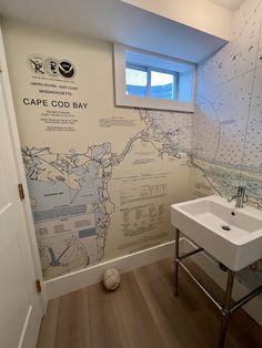 a bathroom with a map on the wall and a white sink in front of it