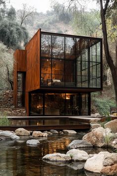 the house is surrounded by rocks and trees, along with a small stream that runs through it