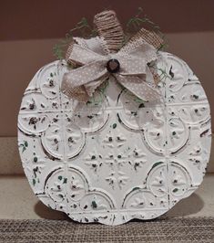 a white pumpkin decorated with burlocks and bows