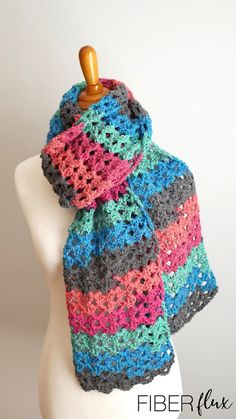 a multicolored crocheted scarf on a mannequin head